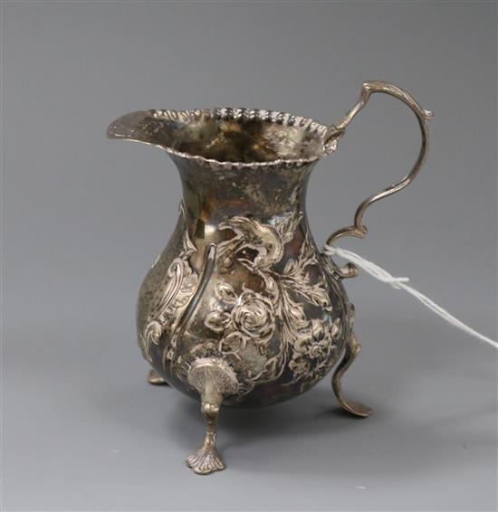 A George III silver cream jug with later embossed decoration.